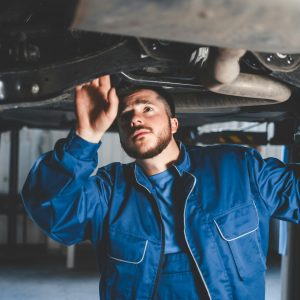Auto mechanic inspects car suspension. Diagnostics of the condition of the car Auto mechanic inspects car suspension. Diagnostics of the condition of the car